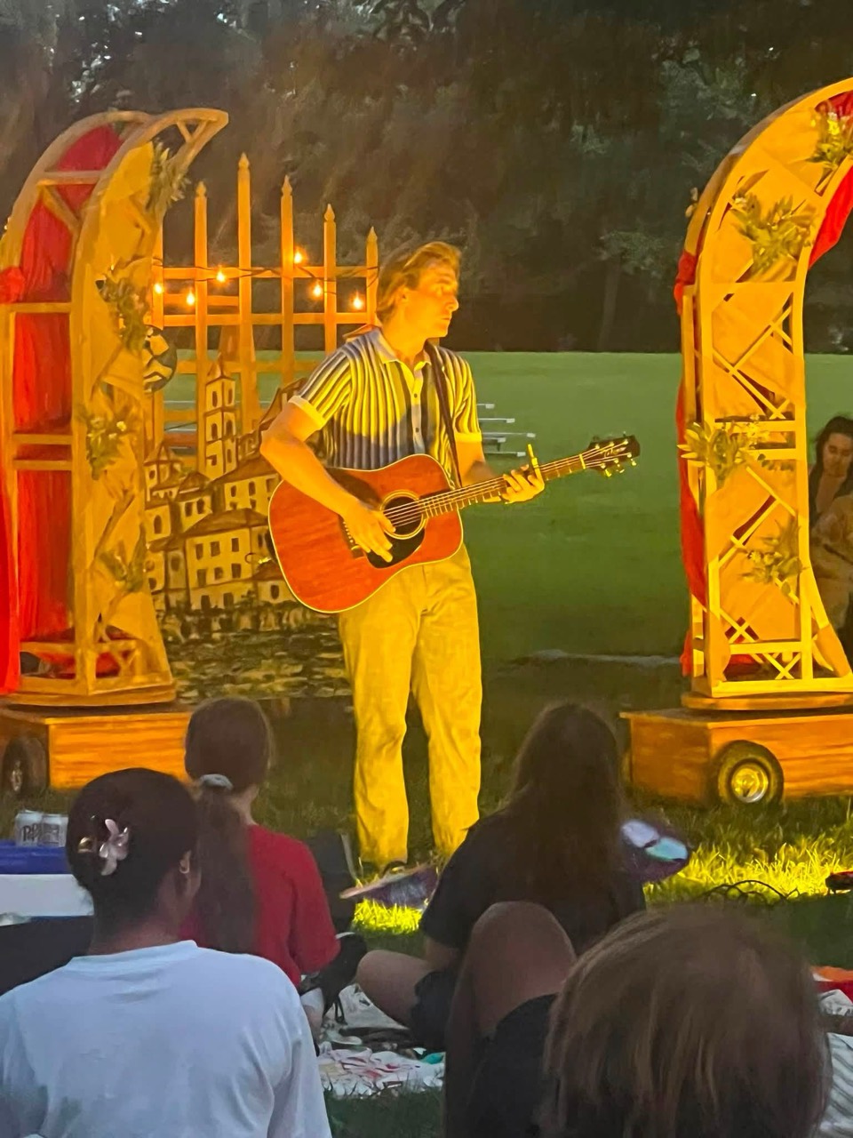 Tristan playing guitar for an outdoor theater audience